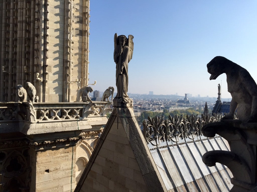 Some gargoyles and the roof of other parts of the cathedral, plus view of Paris in the distance. - - "Morning with Gargoyles at Notre Dame de Paris" - Two Traveling Texans